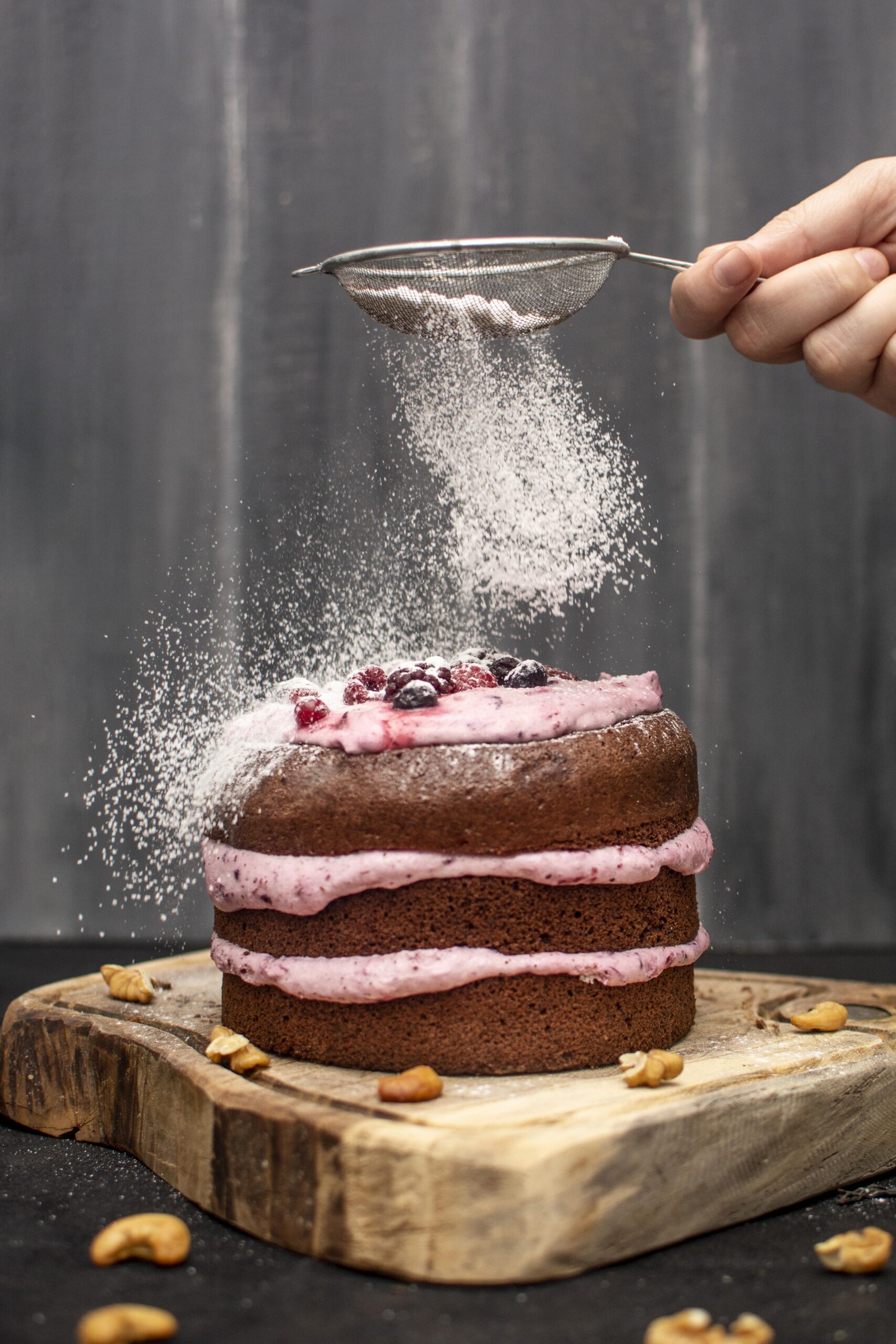 front-view-hand-sieving-powdered-sugar-top-hands